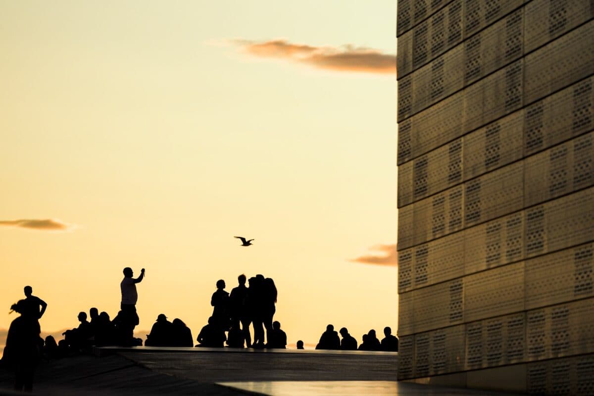 Folk i silhuett mot kveldshimmel