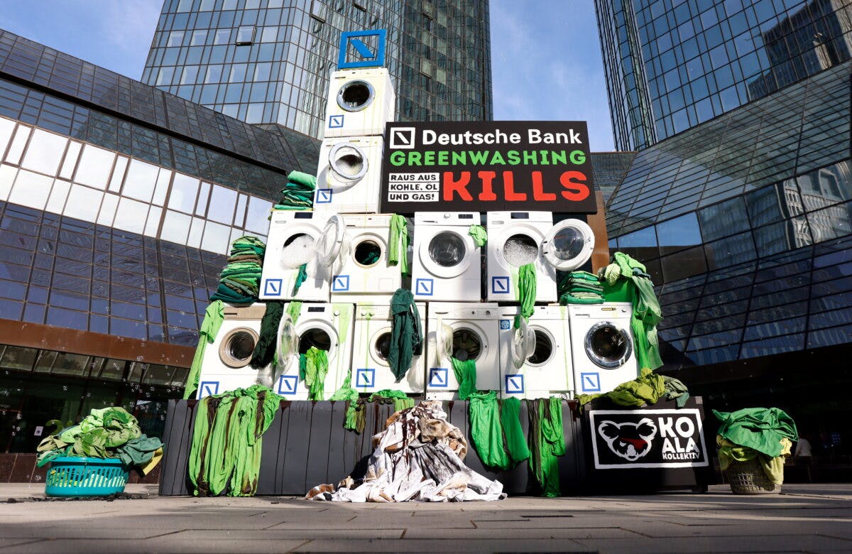 Aktivister med vaskemaskiner og plakater utenfor Deutsche Banks bygning i Frankfurt.