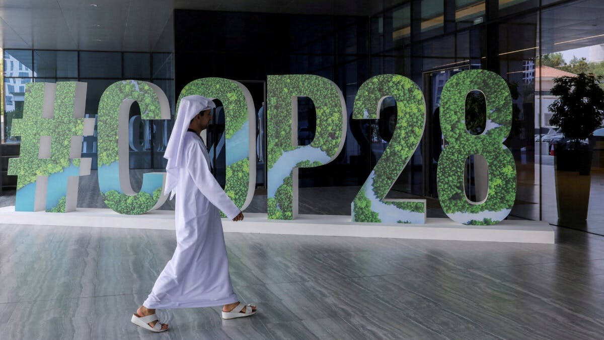 En mann går forbi et skilt som sier COP28.