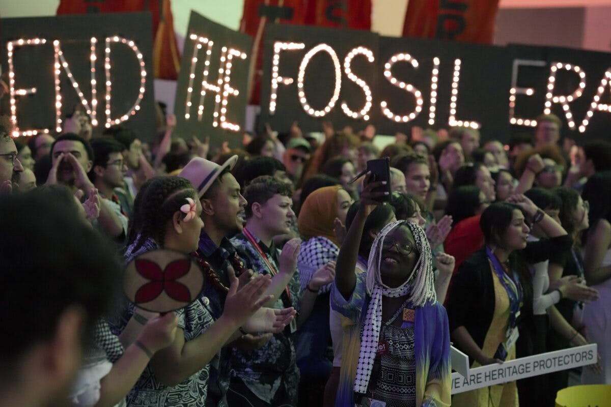En gruppe mennesker holder skilt som sier slutten på fossiltiden.