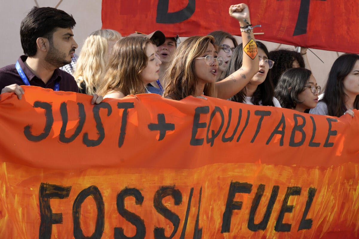 En gruppe mennesker som holder et banner som sier bare rettferdig fossilt brensel.