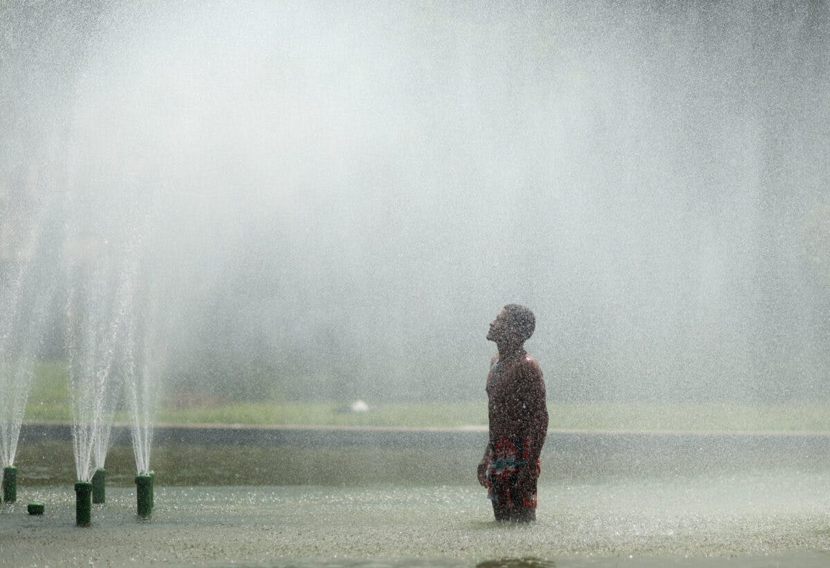 En mann som står foran en vannfontene.