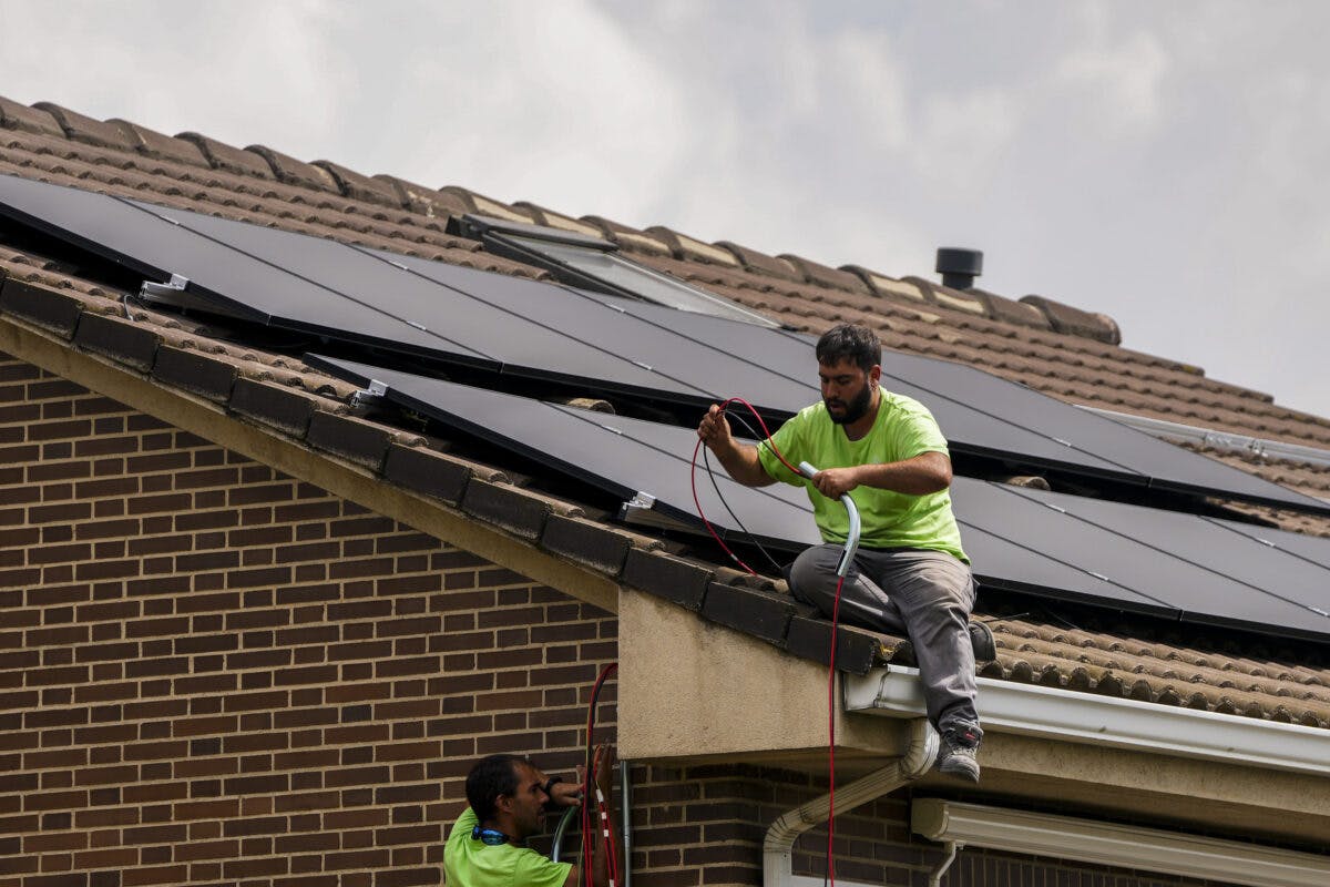 To menn på et tak som installerer solcellepaneler.