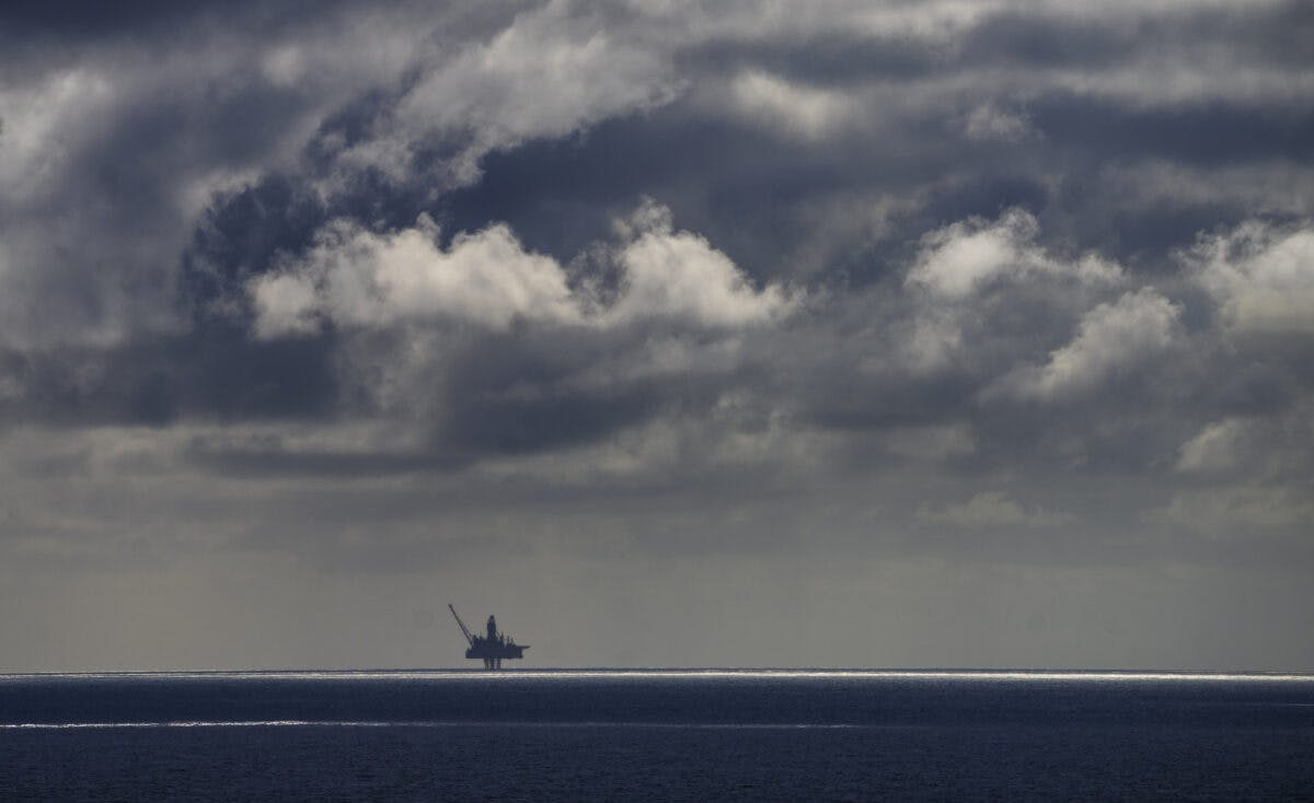 En oljerigg i havet under en overskyet himmel.