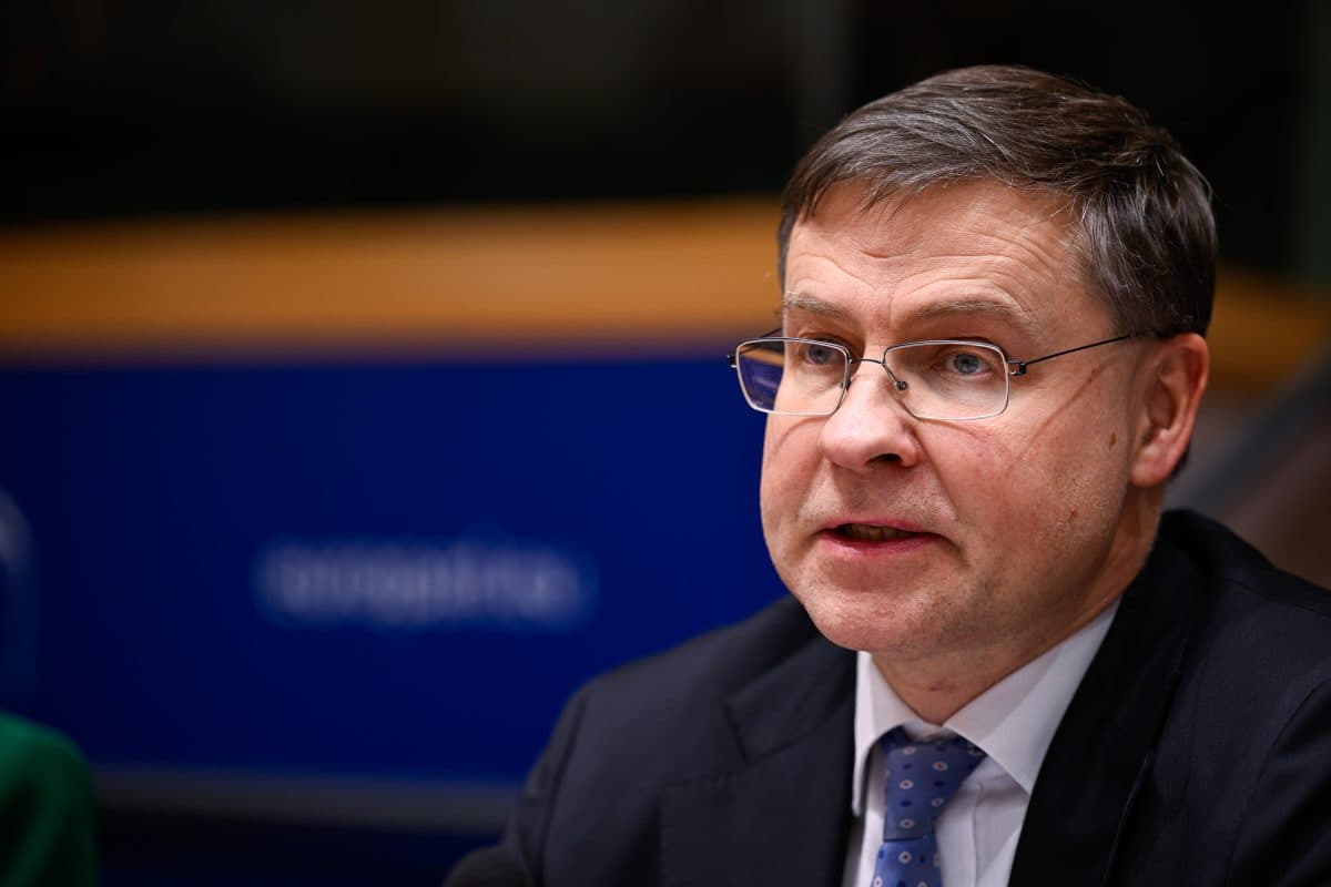 Person i dress og briller snakker på et arrangement.