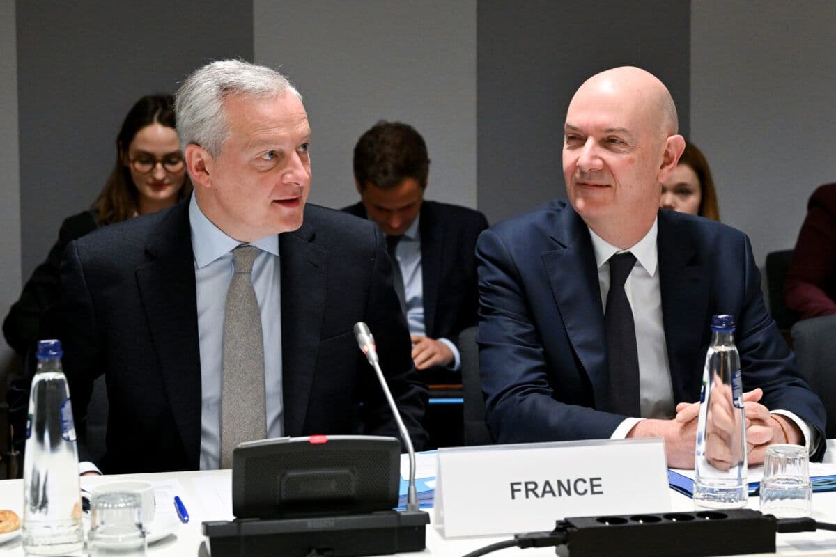 To menn sitter ved et bord og snakker med hverandre.