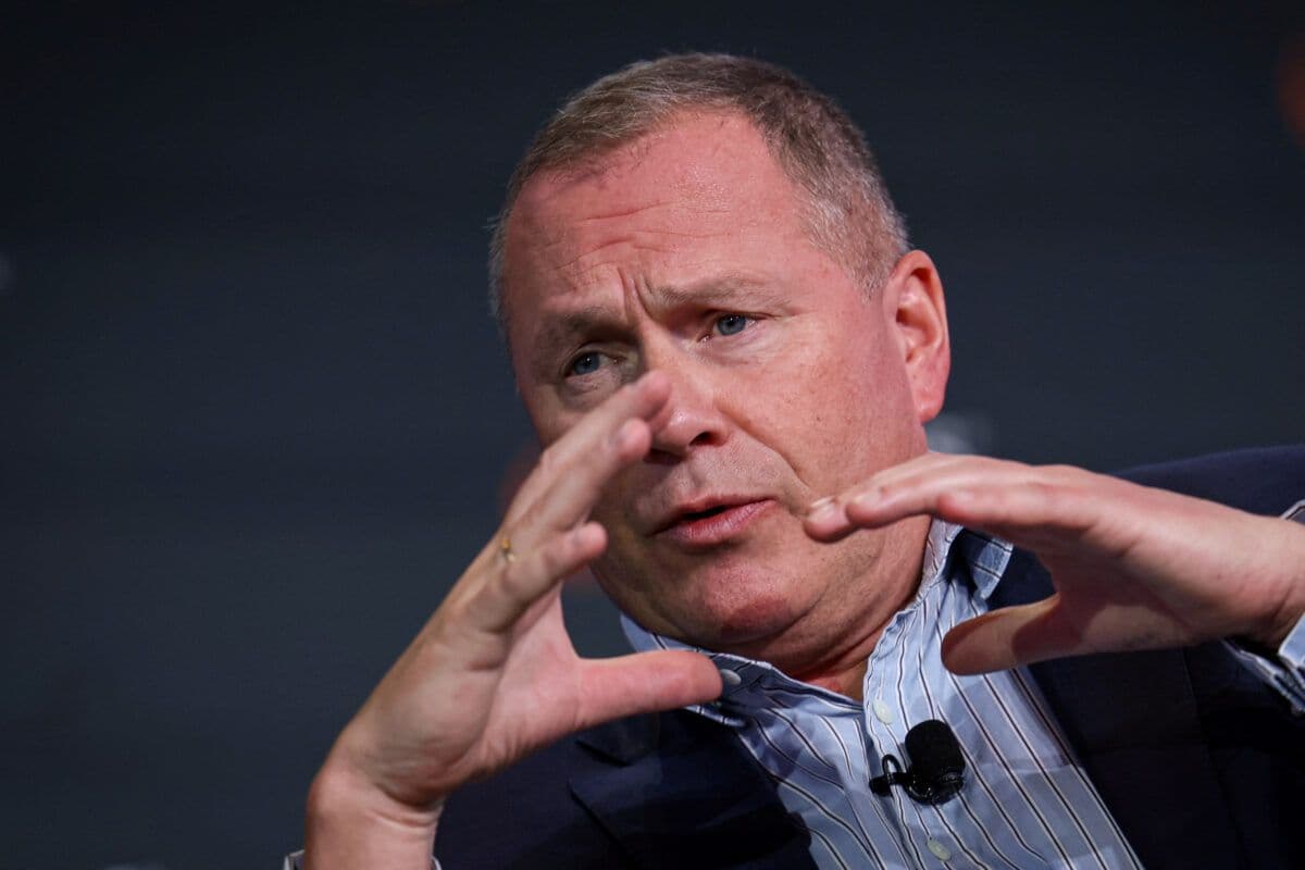 En mann i dress gestikulerer med hendene.