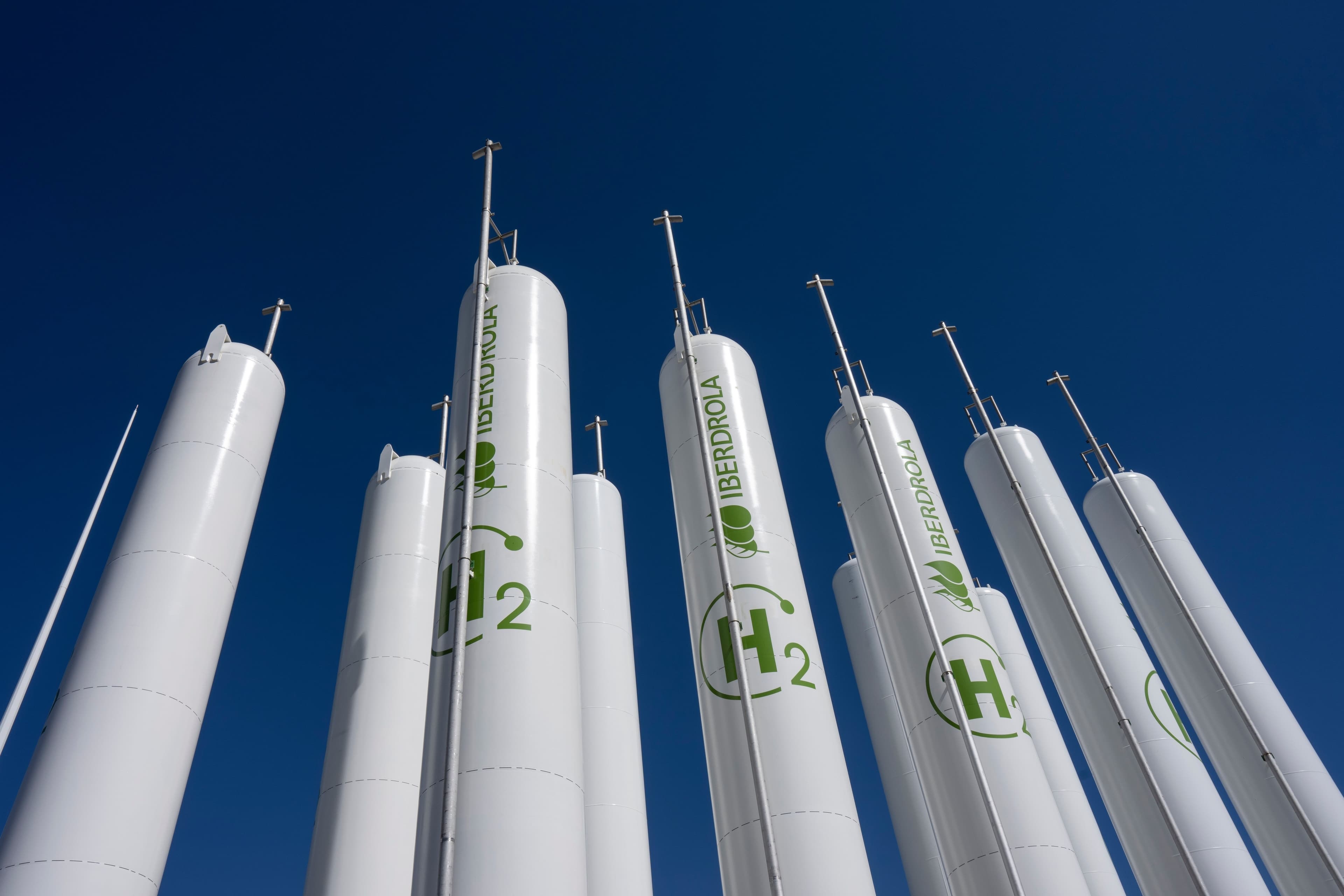 Høye, hvite hydrogentanker fra Iberdrola mot blå himmel.