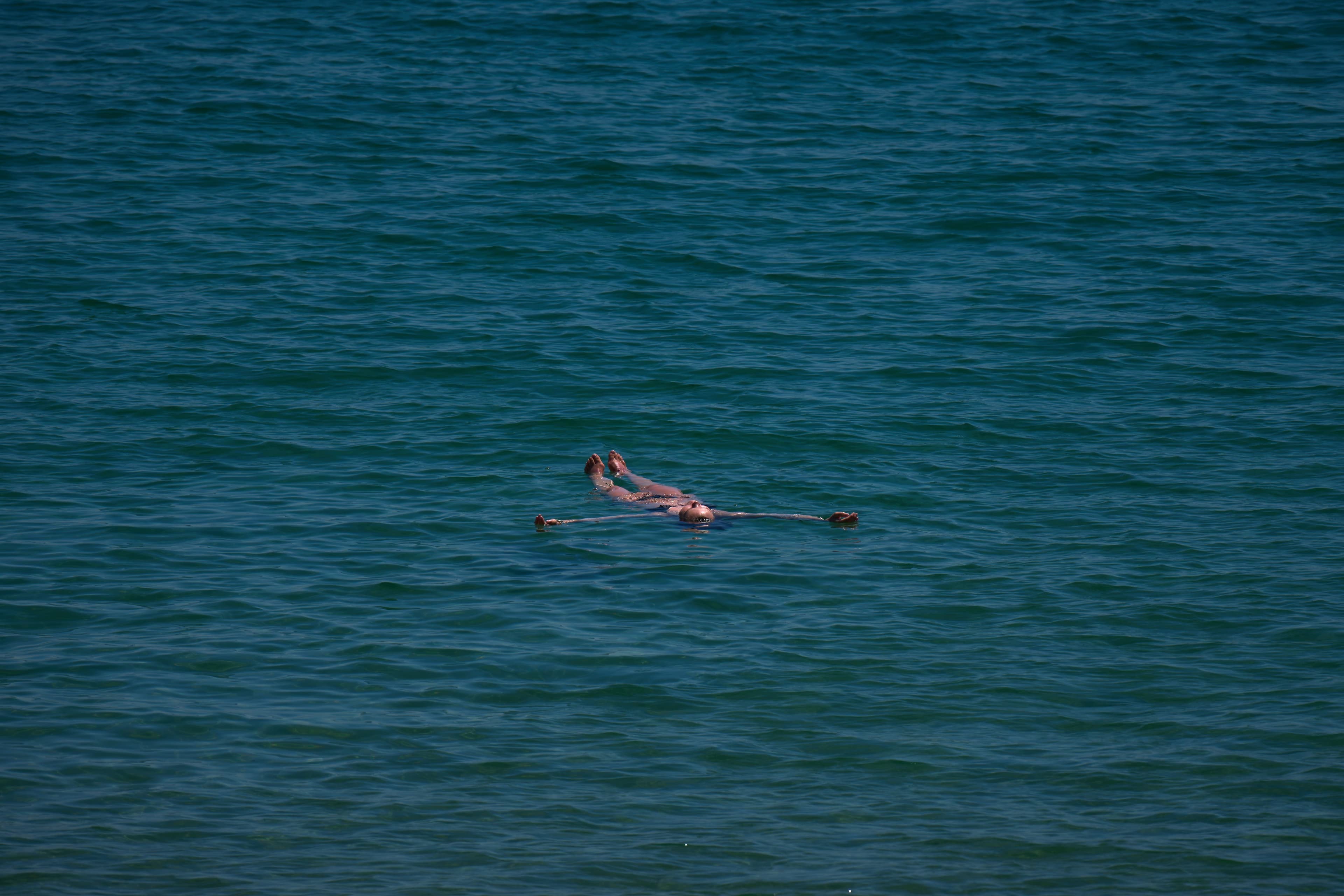 Person som flyter på ryggen i havet.