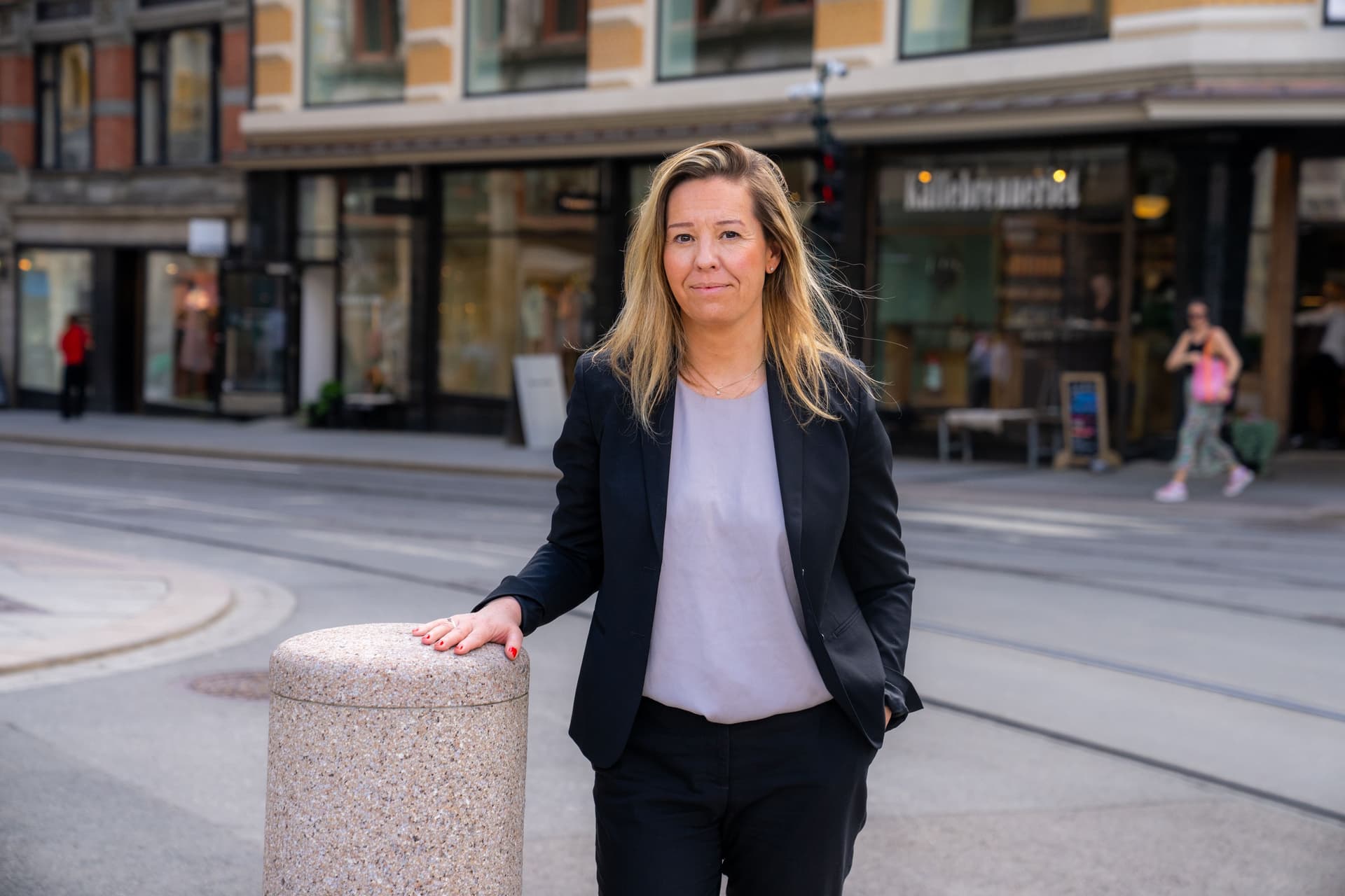 Bildet viser Oda Therese Gipling i mørk dressjakke som står i en bygate med hånden hvilende på en pullert.