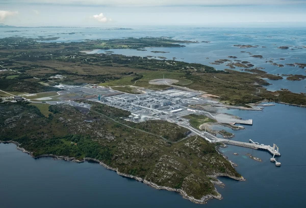 Luftfoto av et industrianlegg som ligger i et steinete kystlandskap omgitt av vann og små øyer.