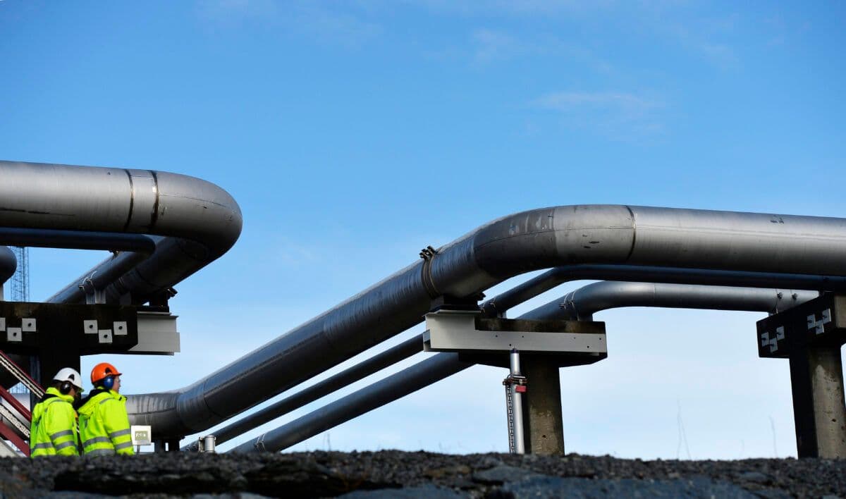 En gruppe arbeidere som står ved siden av rør.