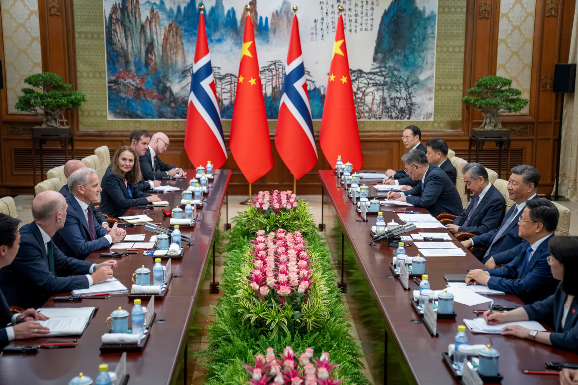 Et formelt møte mellom norske og kinesiske delegasjoner, med nasjonalflaggene deres utstilt.