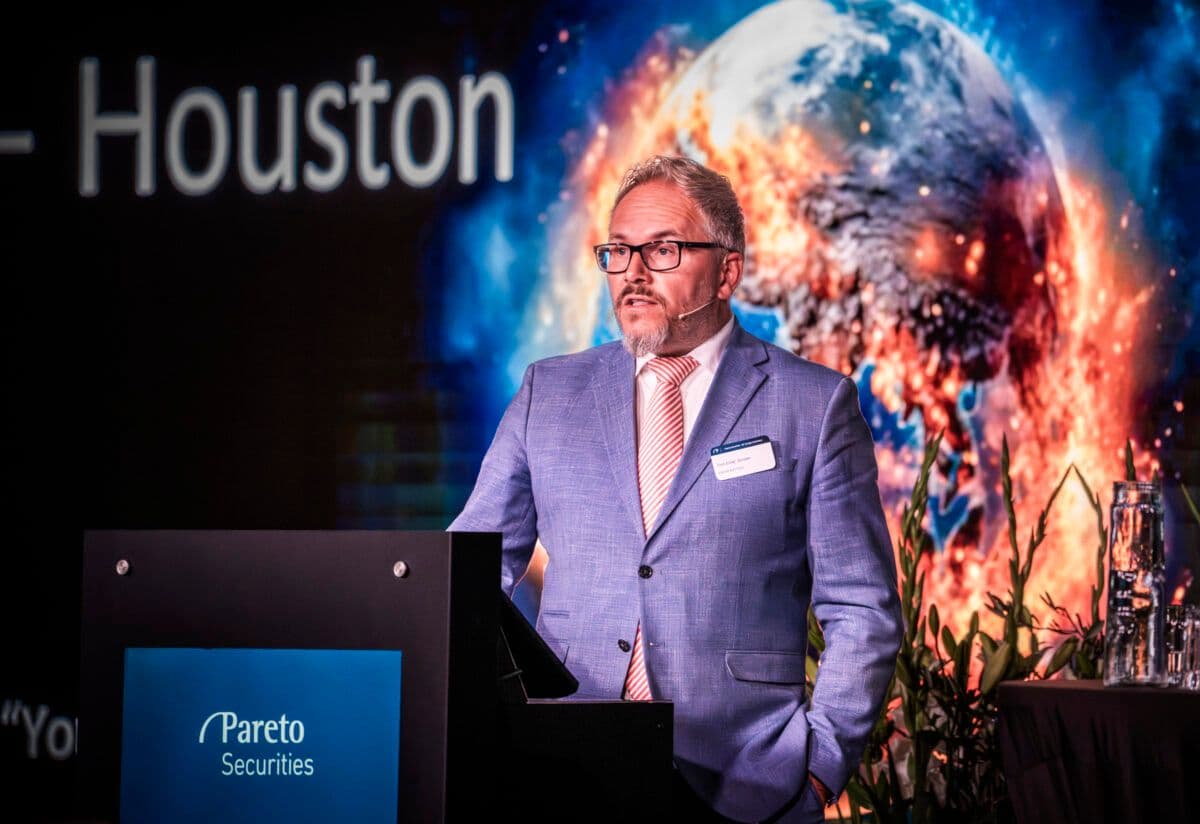 En mann i dress som står på et podium.