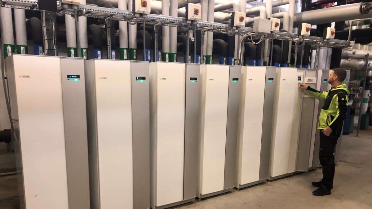 En mann står foran elektriske skap.