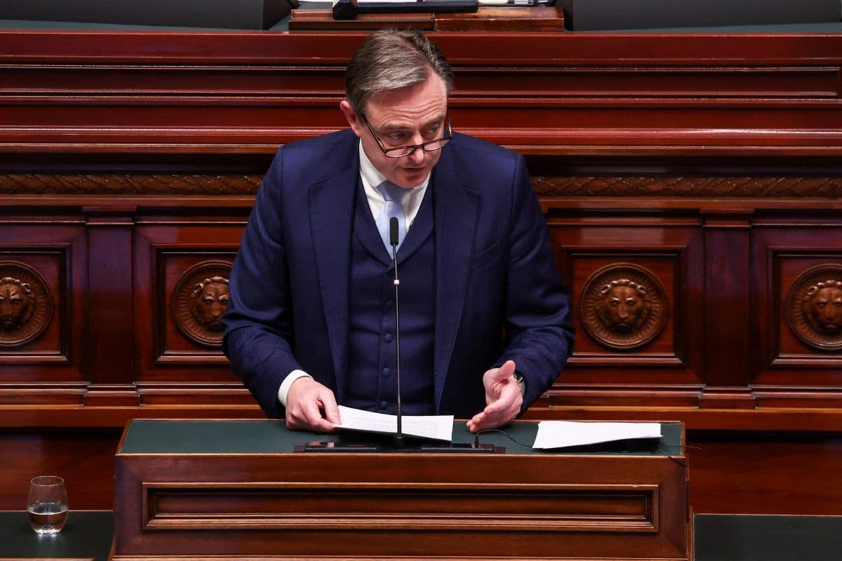 En person i dress taler ved et podium av tre i en formell setting, muligens et lovgivende kammer.