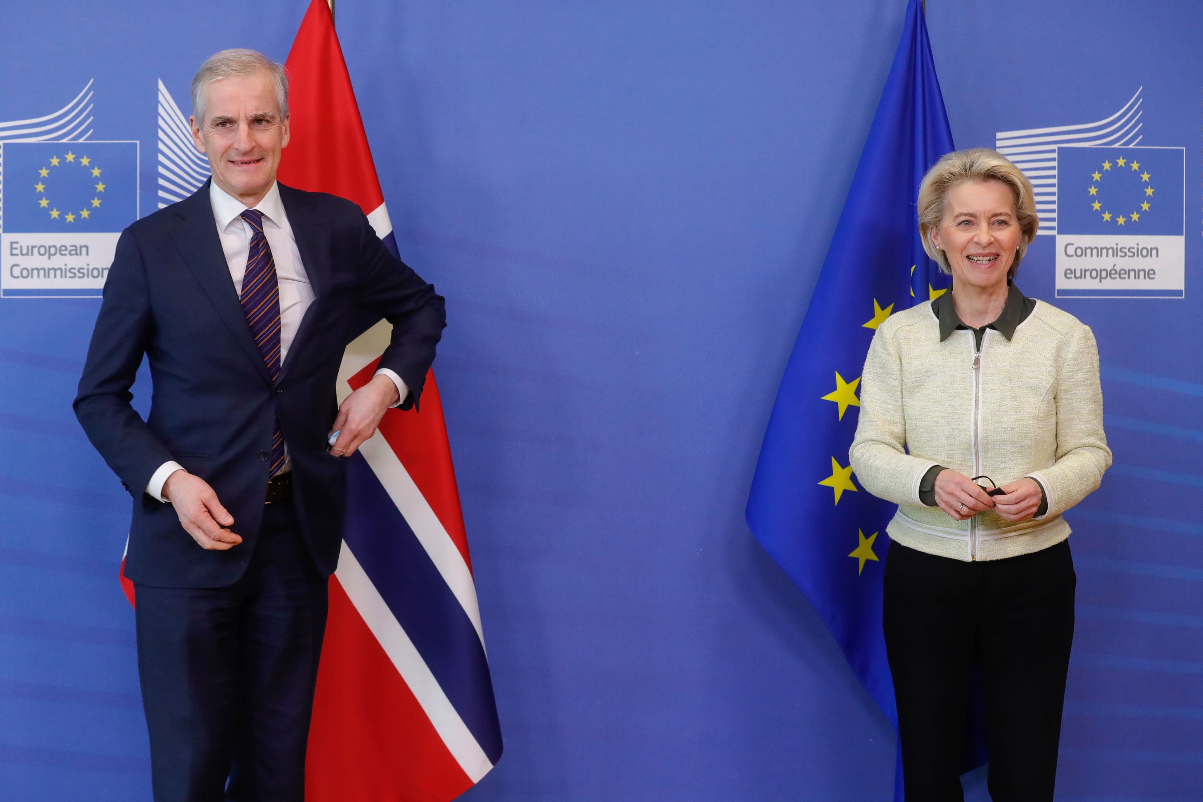 Norges statsminister Jonas Gahr Støre og EU-kommisjonens president Ursula von der Leyen står smilende foran de norske og EU’s flagg.