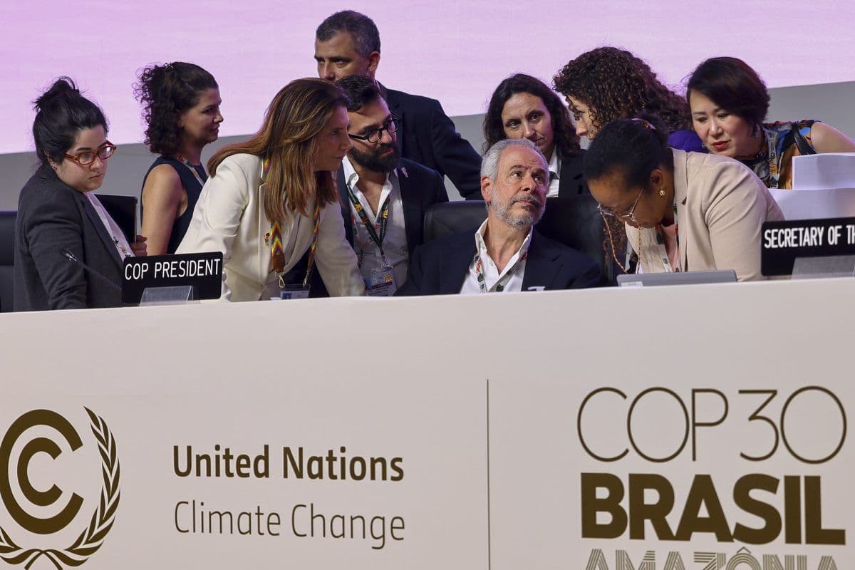 En gruppe tjenestemenn og delegater snakker sammen ved et bord under FNs klimakonferanse COP30 i Brasil.