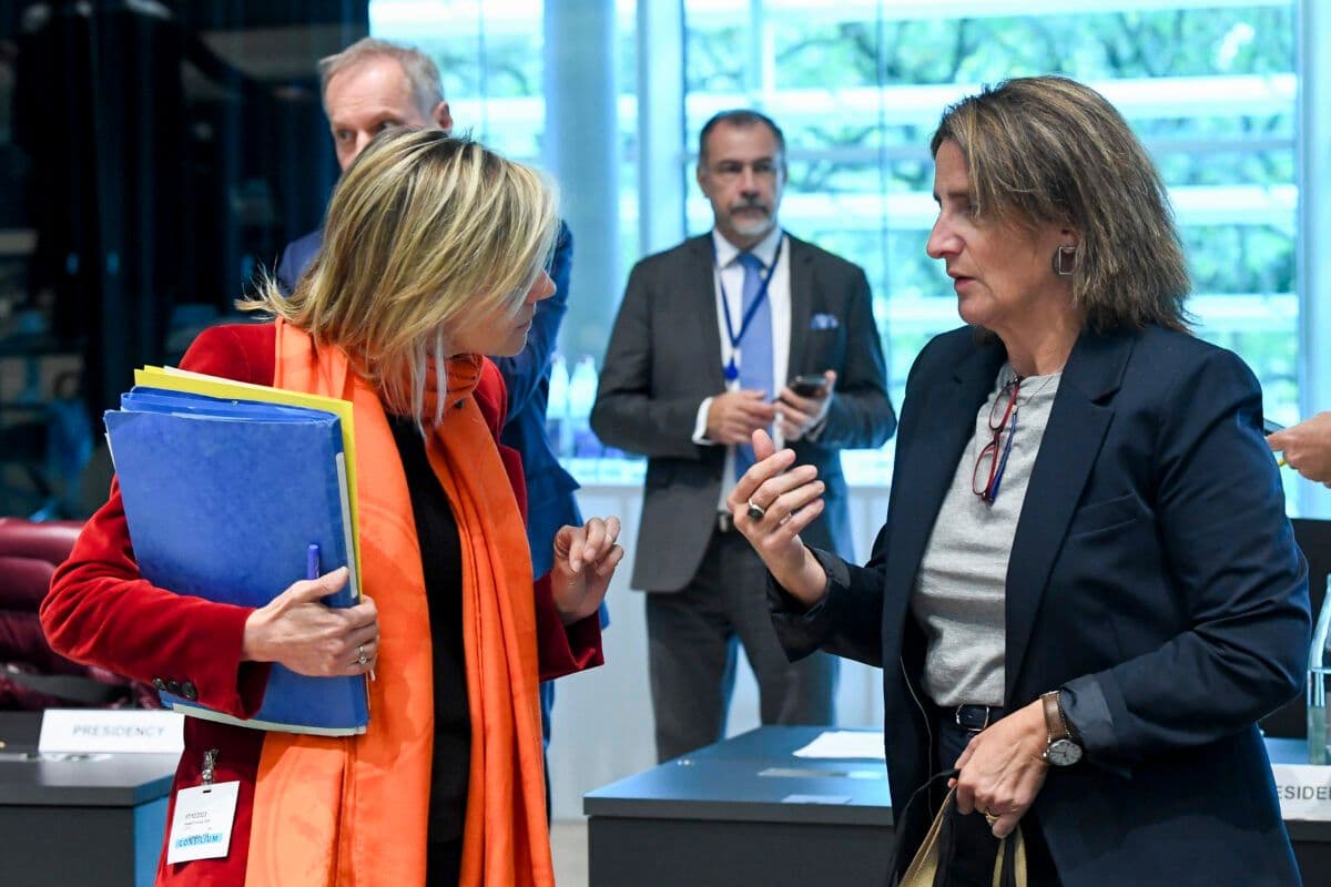 To kvinner snakker med hverandre i et konferanserom.