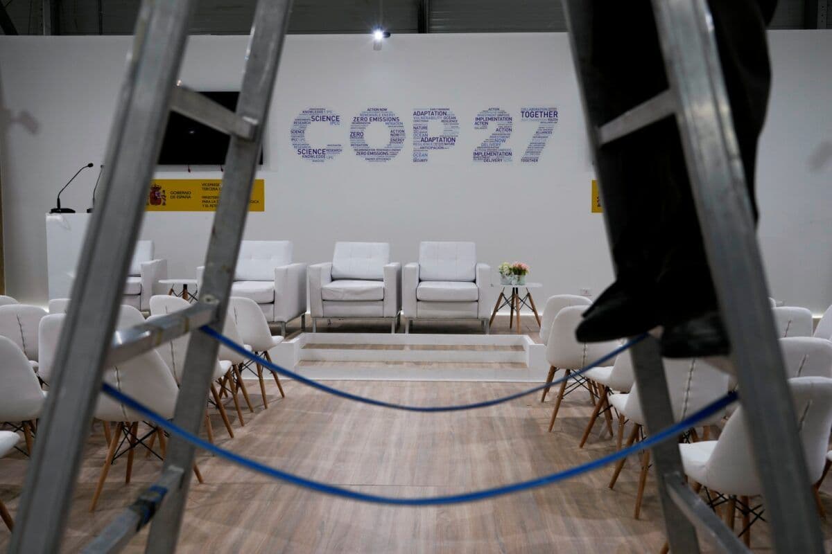 Bena til person i gardintrapp i konferanselokale med COP27 skrevet på vegg i bakgrunnen
