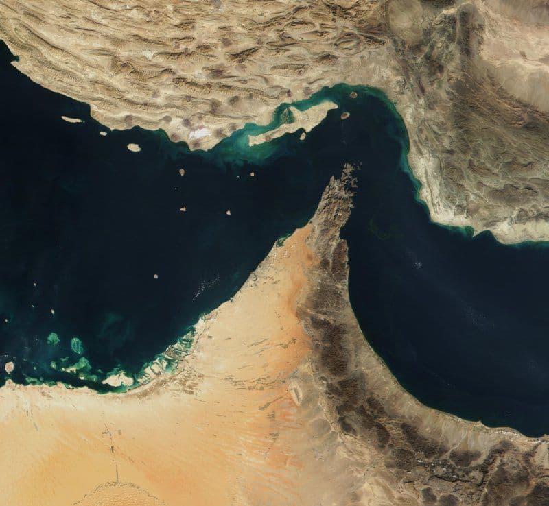To oljepumpejekker i silhuett står foran et kart som fremhever Iran, Saudi-Arabia, Persiabukta og Hormuzstredet.