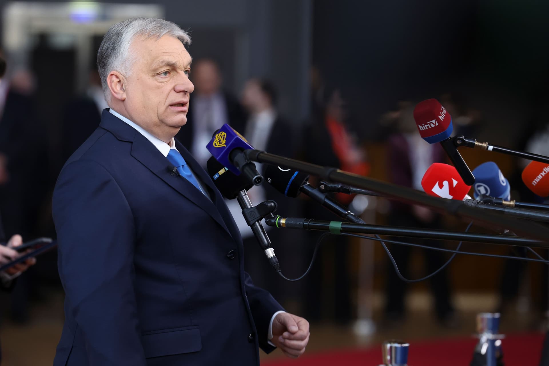 Hungarian Prime Minister Viktor Orbán speaking into a bank of microphones.