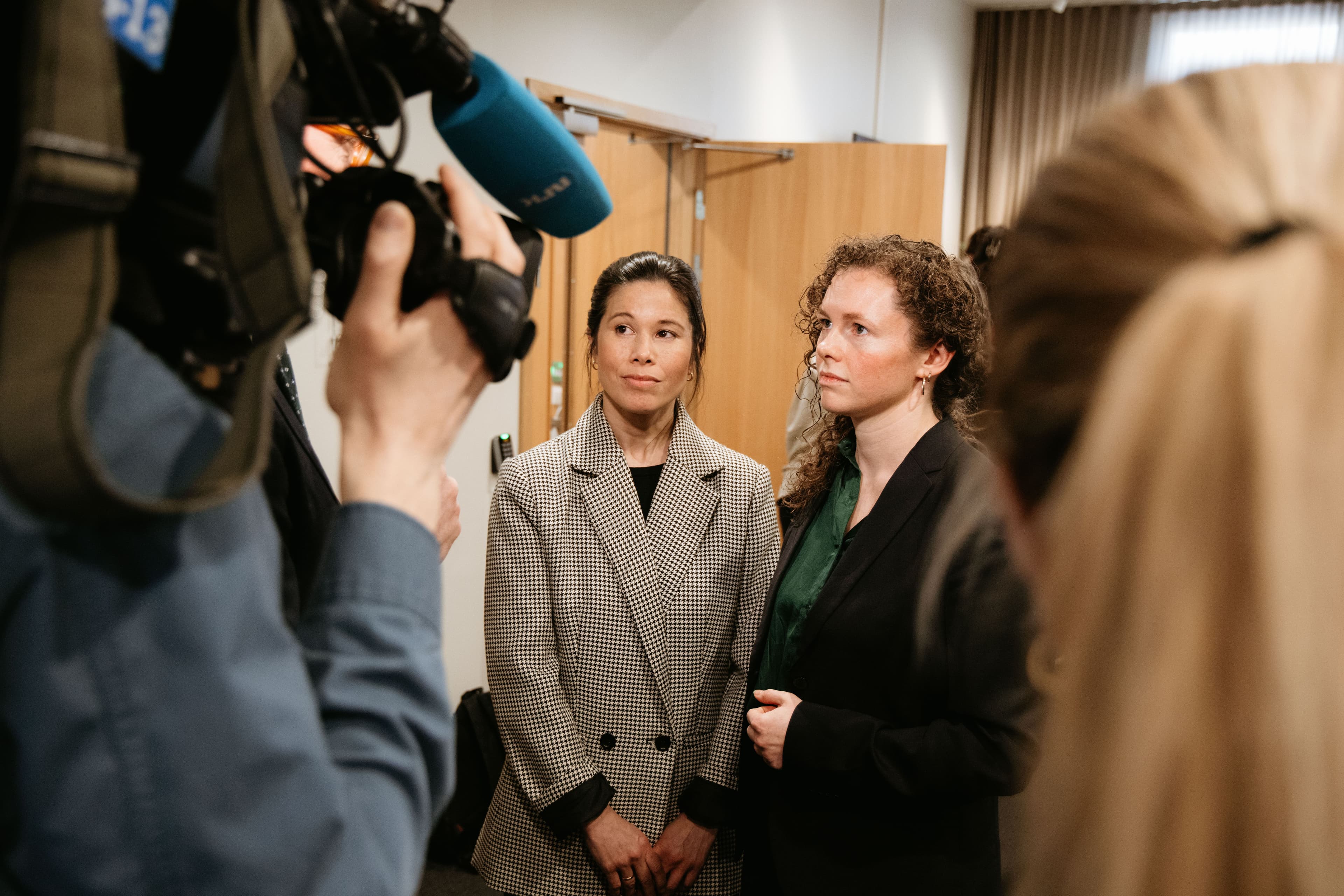 To kvinner blir filmet av en kameramann.