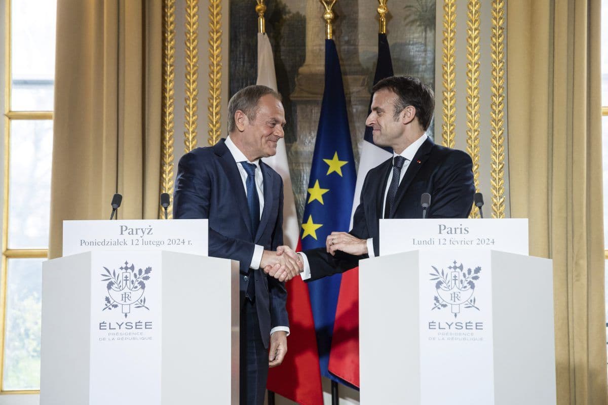 To menn i dress håndhilser på podier merket «Élysée», med franske og EU-flagg i bakgrunnen, under en pressekonferanse.